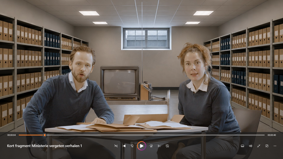 twee rechercheurs zitten gebogen over dossiers in een archiefkelder