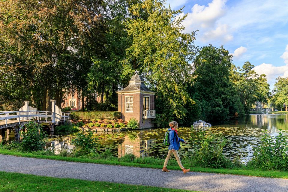 Een vrouw loopt langs de gracht voor Slot Zeist