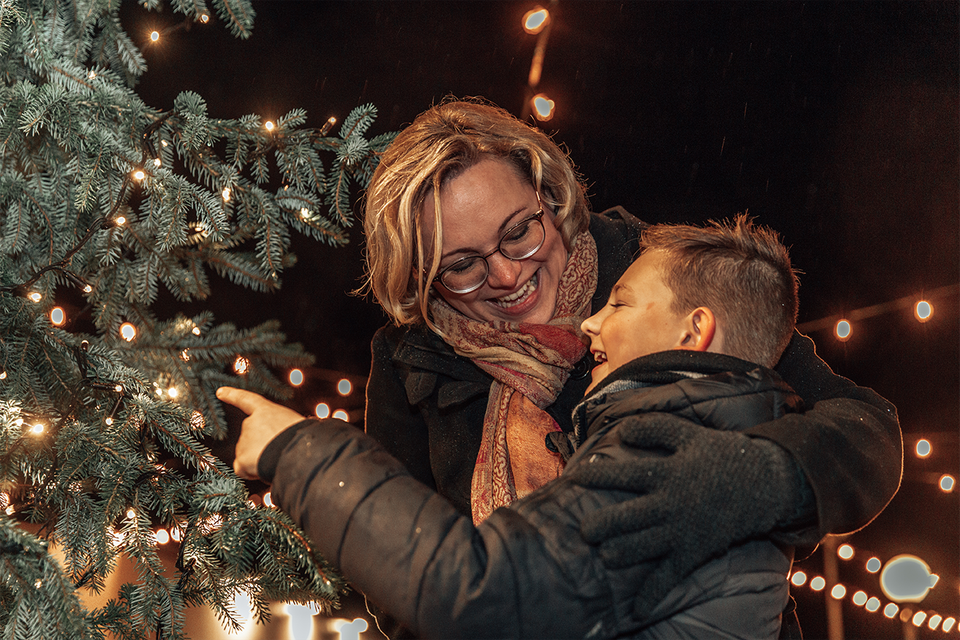 Moeder en kind bij kerstboom