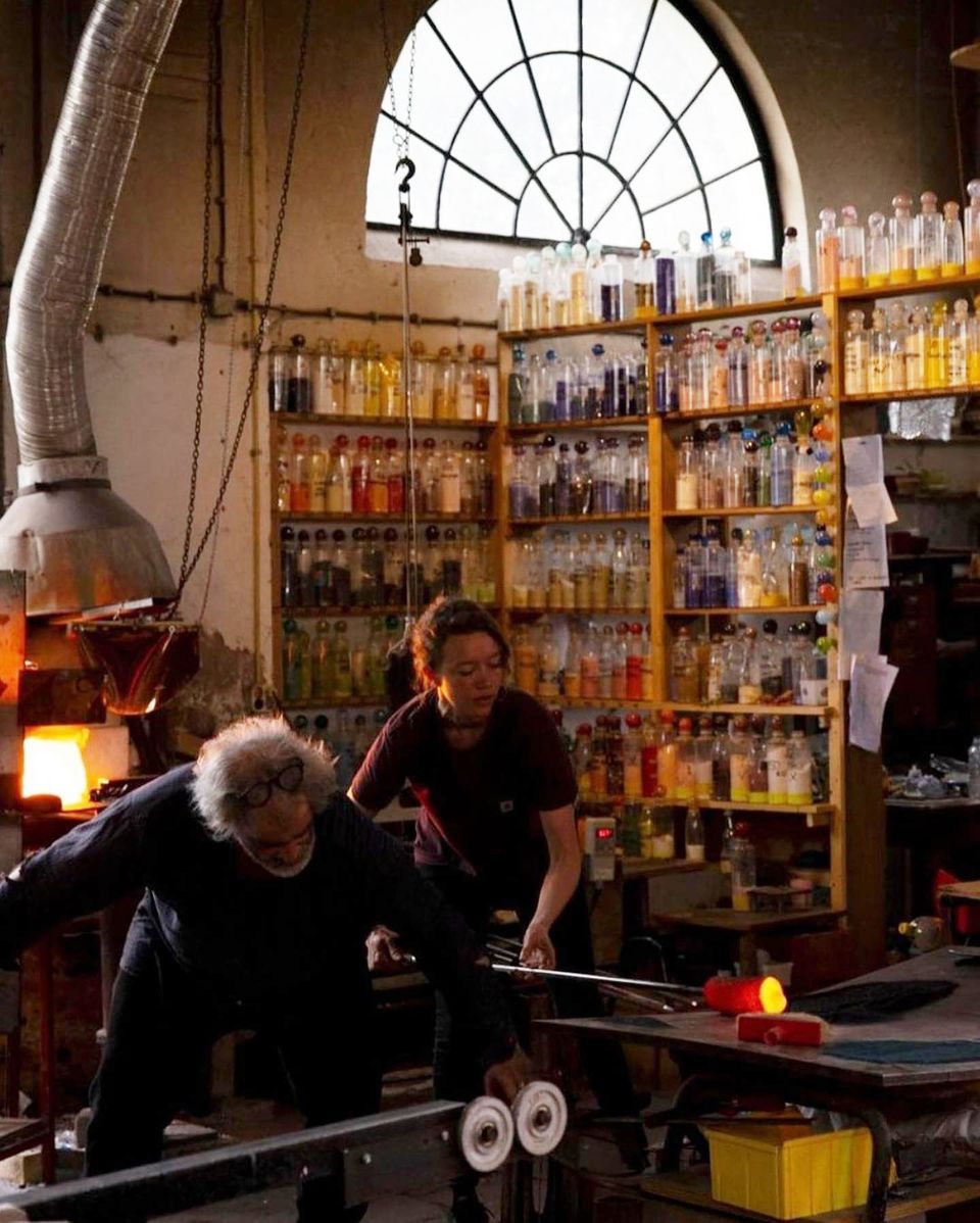 Twee personen zijn glas aan het bewerken.