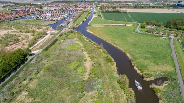 Luchtfoto slingerend havenkanaal Oude-Tonge met natuur