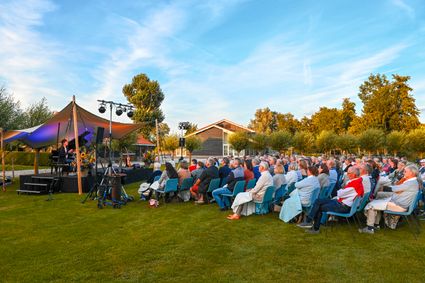 Publiek geniet van een sfeervolle buitenvoorstelling tijdens het Midzomer Theater bij Buitenplaats Kameryck in Kamerik met podium, verlichting en zomerse setting
