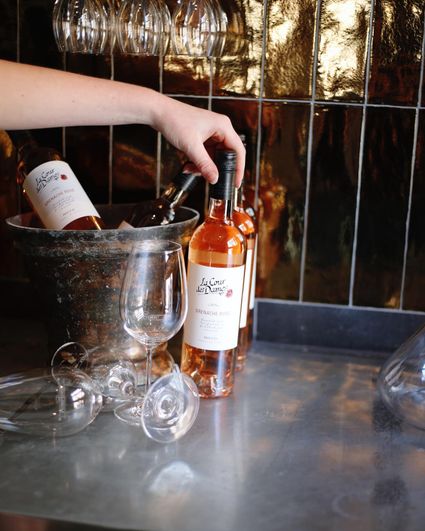 Frans restaurant Gare Pompidou in Woerden, Groene Hart, wijnpresentatie met flessen rosé, wijnglazen en wijnkoeler in sfeervol interieur.