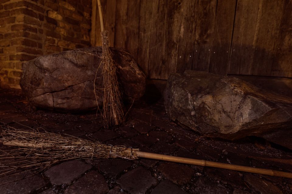 Een donkere foto met een bezemsteel van een van de heksen.