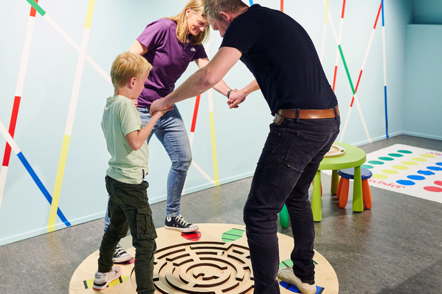Twee ouders en een kind doen een XL spel