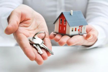 Someone holding a key and a small house