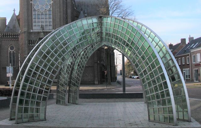kunstwerk van kruislings gebogen staal en groen glas