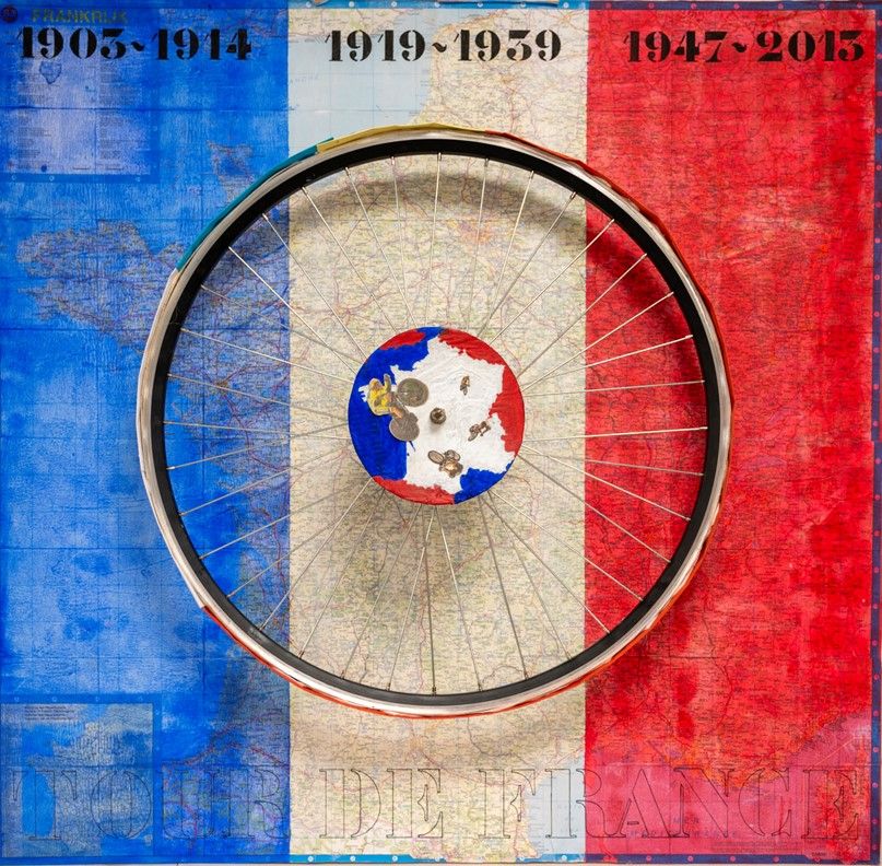 Kunstwerk met een fietswiel tegen de Franse vlag, met kaarten van Frankrijk en jaartallen die verwijzen naar de geschiedenis van de Tour de France.
