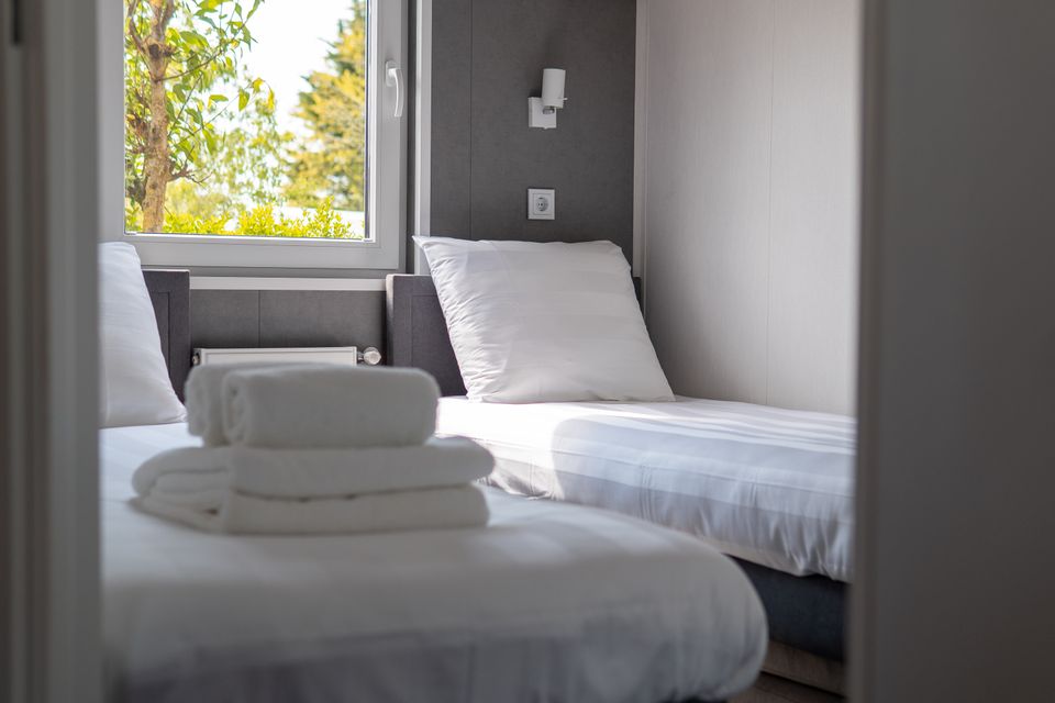 Zweites Schlafzimmer mit zwei Einzelbetten in einem 4-Personen-Chalet auf dem Camping De Wulp