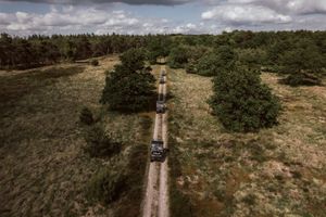 Elektrische terreinauto's rijden door de Drentse natuur.