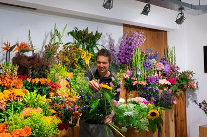Eigenaar Koen staat tussen bloemen in alle kleuren
