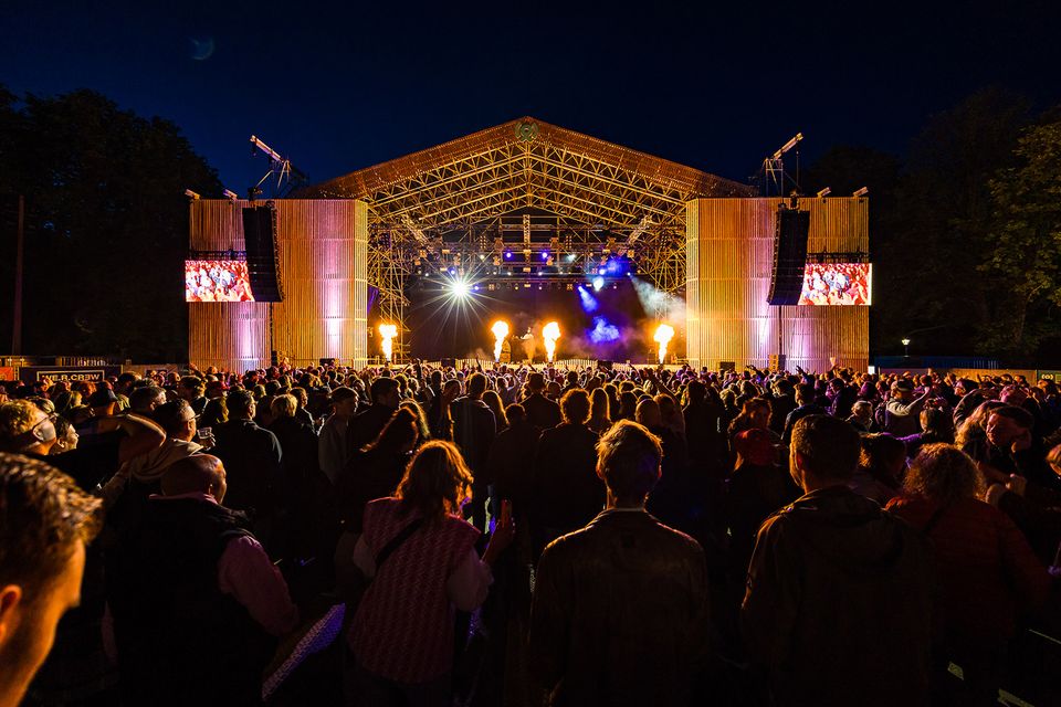 Avondbeeld van Festival ’t Wonder in Woerden met een groot podium, lichtshow en een volle menigte bezoekers.