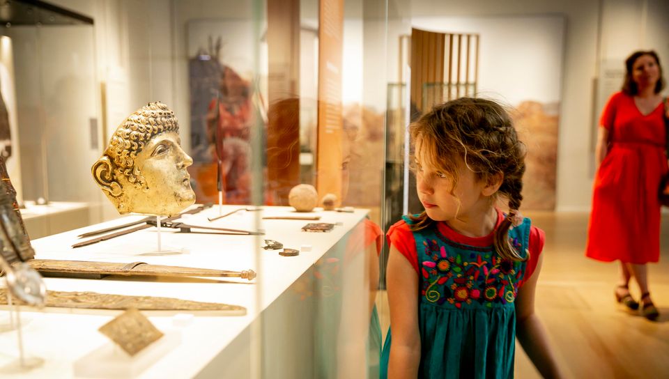 Meisje bekijkt Romeins masker in Rijksmuseum van Oudheden Leiden