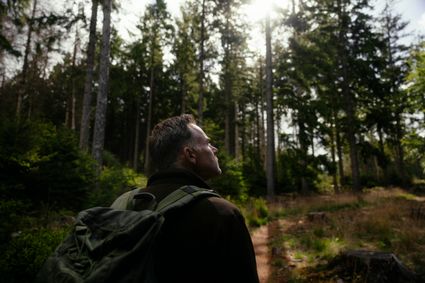 Een man wandelt in het bos.