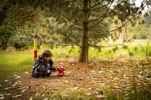 Jongetje knielend bij een kabouter