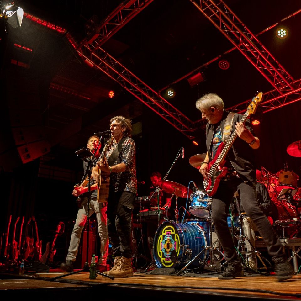 Kleurrijke foto van de muziekband in actie, rode verlichting.