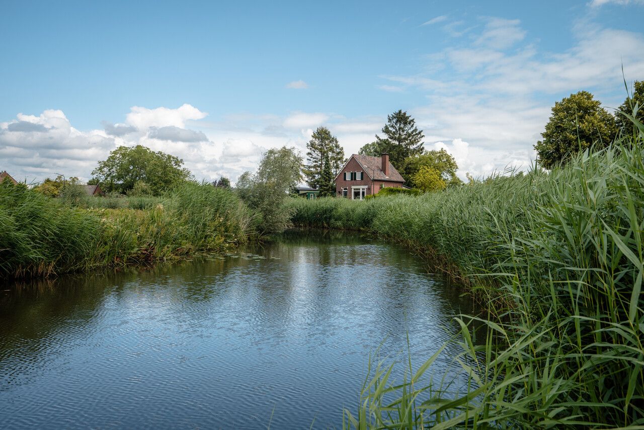 Een huis aan het water in peppellandschap van de Meierij