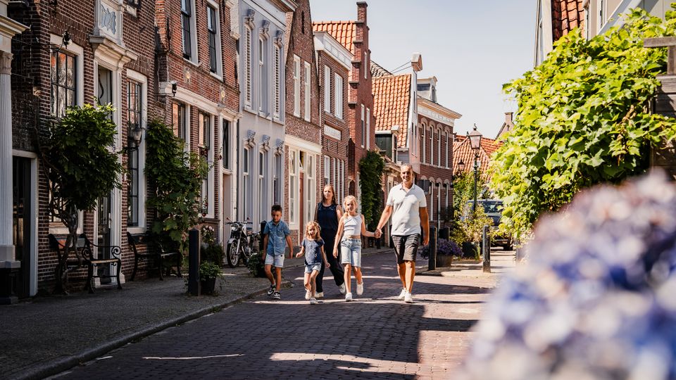 Een gezin die door de straten van Edam loopt