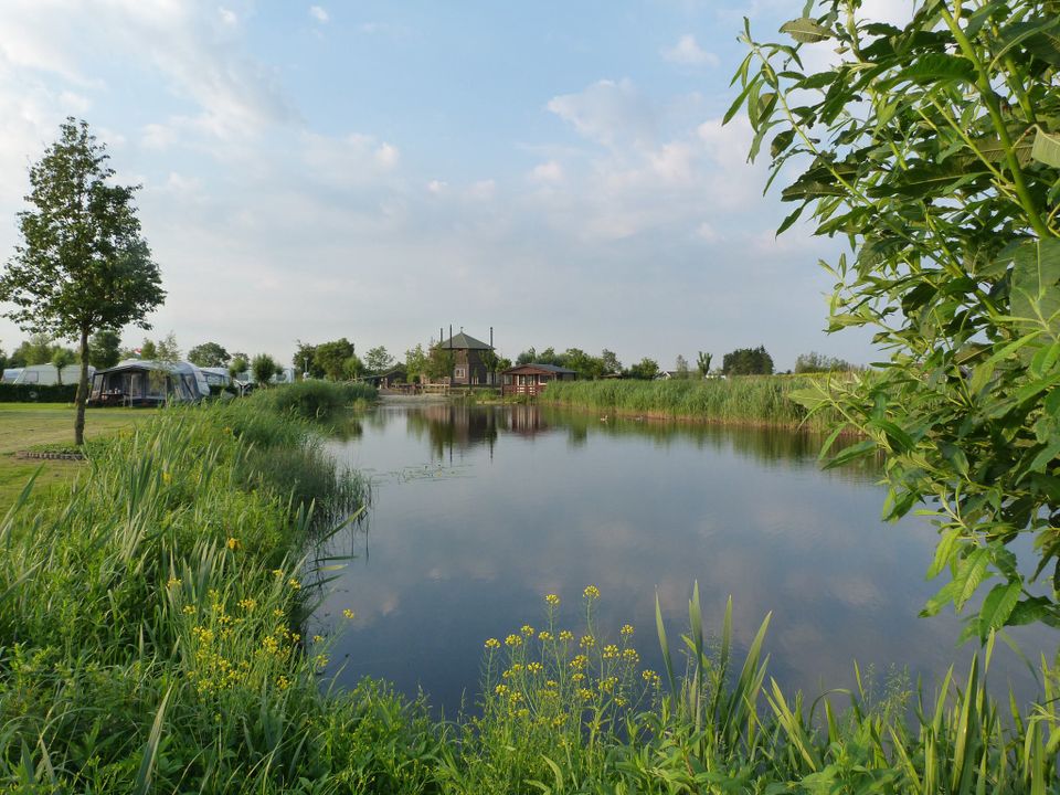 Uitzicht op het water met op de achtergrond camping polderflora