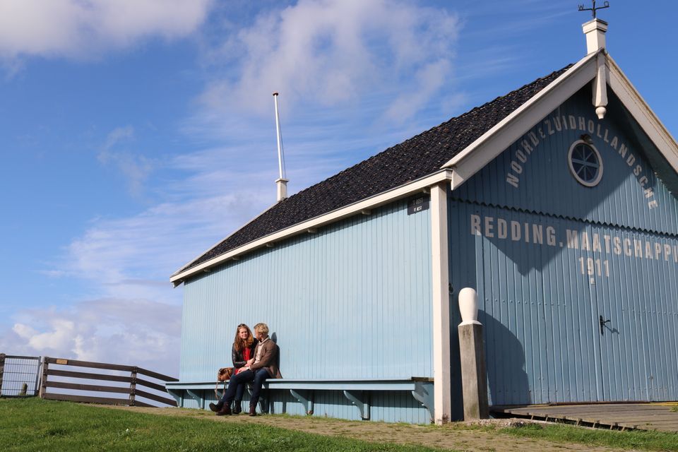 twee mensen naast elkaar op het bankje van het reddingshuisje in hindeloopen