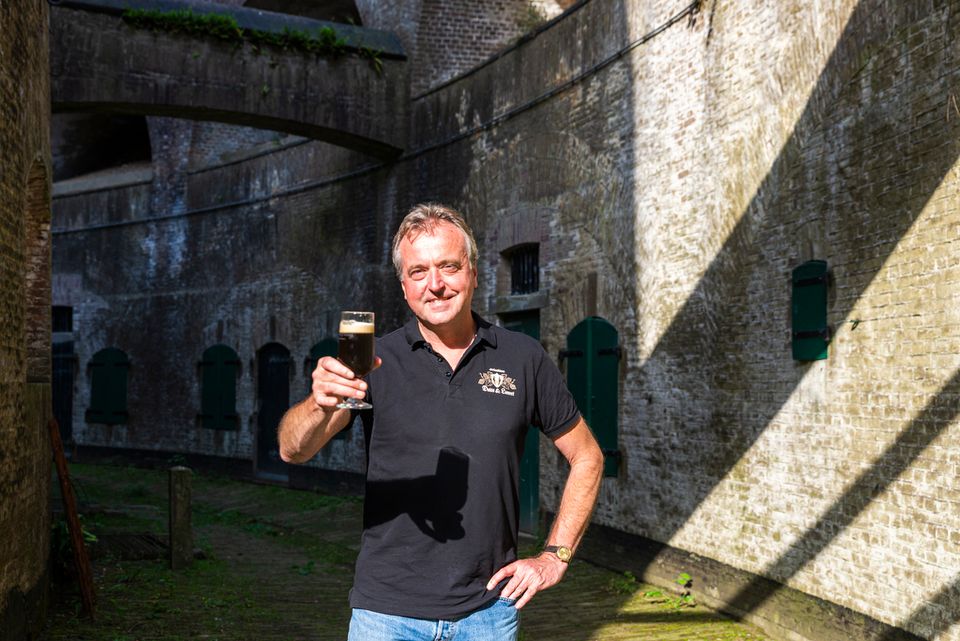 Marco Lauret, ondernemer op Fort Everdingen, staat in de omgang van het fort met een glas bier in zijn hand.