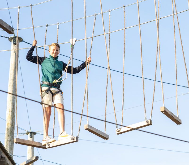 Jongen aan het vrijklimmen klimpark