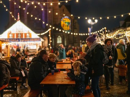 Gezin die een warme chocomel drinkt op de Markt in Delft