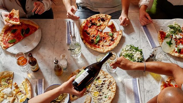 aan tafel met een pizza en een heerlijke salade