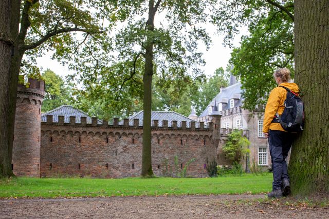 Een wandelaar kijkt naar een kasteel langs de Liberation Route Brabant.