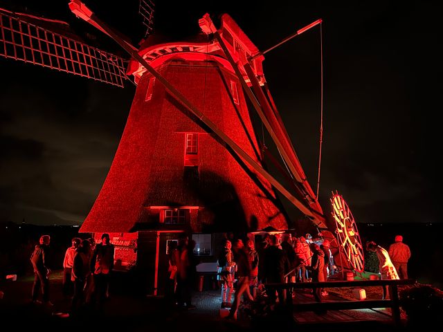 In het rood belichte Waterloosmolen tijdens molennacht van dichtbij in Rijpwetering