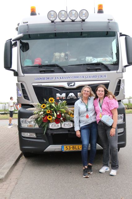 Twee deelnemers poseren voor een versierde MAN-vrachtwagen tijdens de Truckrun Groene Hart.