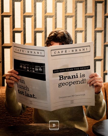 Man met krant met op voorkant nieuws dat Brani is geopend