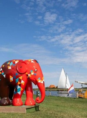 Beschilderde olifant van de Elephant Parade in Gaasterland met een zeilboot op de achtergrond
