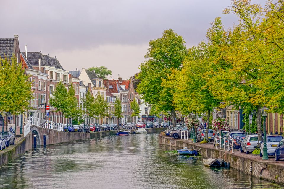 Atmospheric image of a beautiful canal in Leiden surrounded by trees.