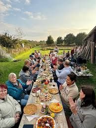 mensen aan een lange tafel buiten die eten