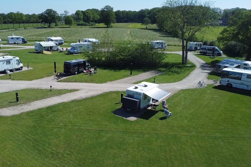 Campers staan op een grasveld met camperplaatsen in Drenthe.
