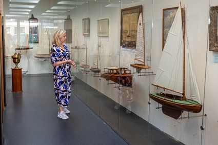 Nynke de Jong voor een vitrine met zeilboten in het Fries Scheepvaartmuseum