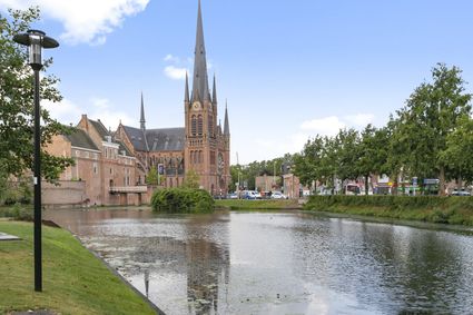 Stadswandeling Woerden, provincie Utrecht, Groene Hart, zicht op de neogotische Petruskerk met hoge torenspitsen en roosvenster tijdens een historische route door de binnenstad.