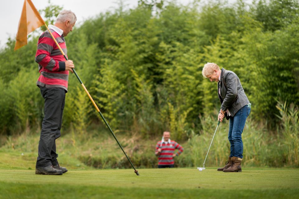 Twee mannen en een vrouw golven in de Noordoostpolder, Flevoland