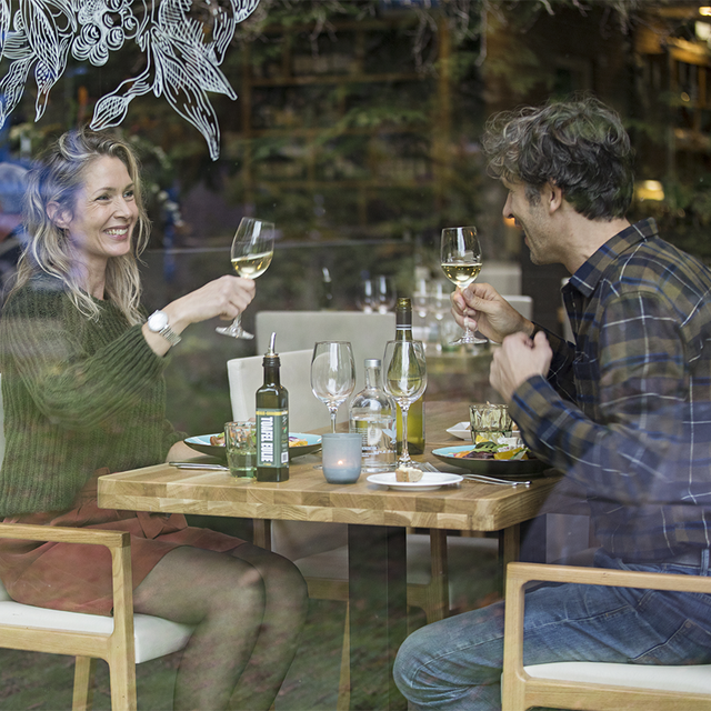 Een stel is romantisch aan het dineren met een glaasje wijn.