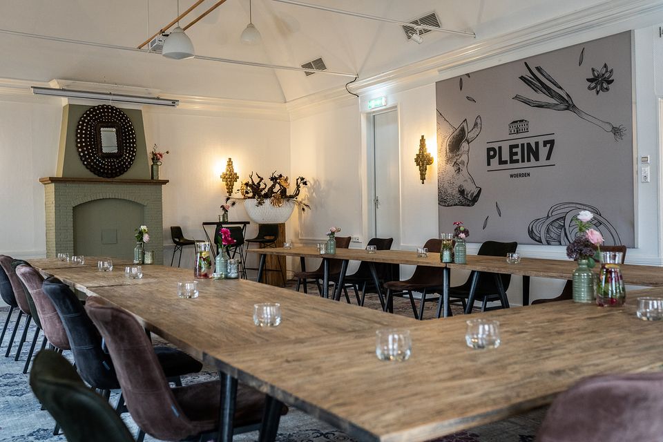 Vergaderruimte en restaurant Plein 7 in Woerden met lange tafels en sfeervolle inrichting.