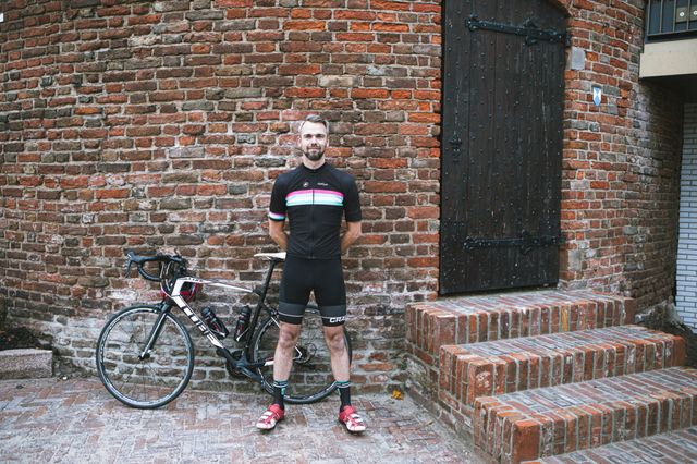 Fietsfanaat Peter staat in zijn wieltenue naast zijn fiets