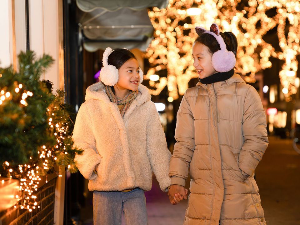 Twee zusjes die lopen tussen de lichtjes tijdens de kerstvakantie in Delft