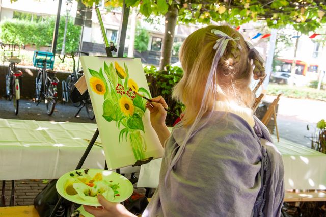 Jonge meid schildert een bloem op een schildersdoek tijdens Bussum Cultureel