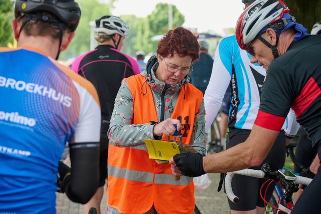 Vrijwilliger zet stempels tijdens de Fietselfstedentocht in Sloten.