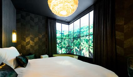 Chique, donkere hotelkamer met kingsize bed.