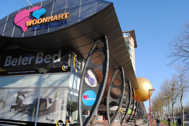 De buitenkant van het gebouw van Woonhart met logo's er op.