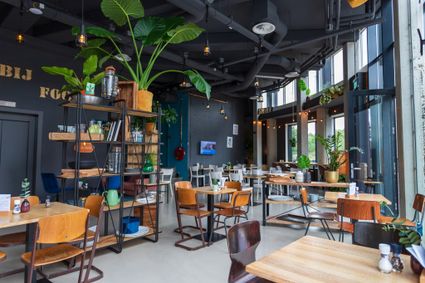 In een restaurant staan veel stoelen en tafels.