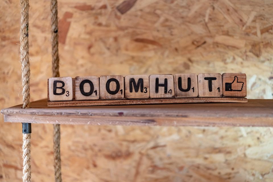 Houten Scrabble letters die samen het woord 'boomhut' vormen