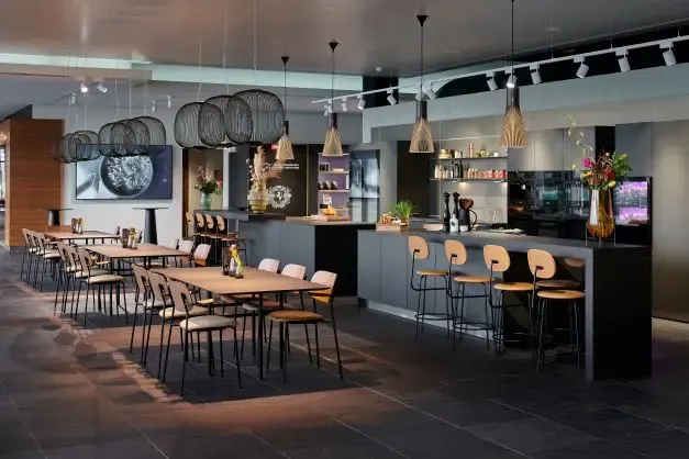 Een ruimte met bar, tafels en stoelen.